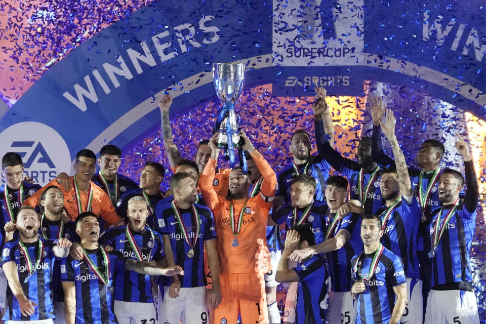 Inter Milan's goalkeeper Samir Handanovic holds the trophy as he celebrates with his teammates after winning the Italian Super Cup final soccer match between AC Milan and Inter Milan at the King Saud University Stadium, in Riyadh, Saudi Arabia, Wednesday, Jan. 18, 2023. Inter Milan won 3-0. (AP Photo/Hussein Malla)