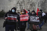 FILE - In this Feb. 14, 2021 file photo, activists hold placards reading 'Islamophobia is enough' and 'Stop Zemmour' during a gathering in Paris. Eric Zemmour is a rabble-rousing television pundit and author with repeated convictions for hate speech who is finding large and fervent audiences for his anti-Islam, anti-immigration invective in the early stages of France's presidential race. (AP Photo/Thibault Camus, File)