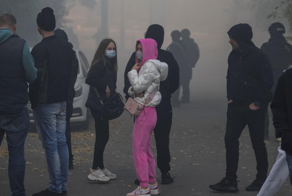 Local residents look on as smoke rises after a Russian drones strike, which local authorities consider to be Iranian made unmanned aerial vehicles (UAVs) Shahed-136, amid Russia's attack on Ukraine, in Kyiv, Ukraine October 17, 2022. REUTERS/Gleb Garanich