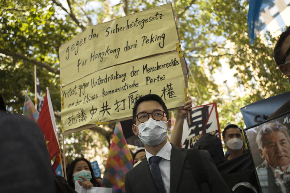 FILE - In this Sept. 1, 2020, file photo, Hong Kong activist Nathan Law, center, takes part in a protest during the visit of Chinese Foreign Minister Wang Yi in Berlin, Germany. Hong Kong police on Monday, July 3, 2023, accused eight self-exiled pro-democracy activists, including Nathan Law, of violating the territory's tough National Security Law and offered rewards of 1 million Hong Kong dollars ($127,600) each for information leading to their arrests. (AP Photo/Markus Schreiber, File)