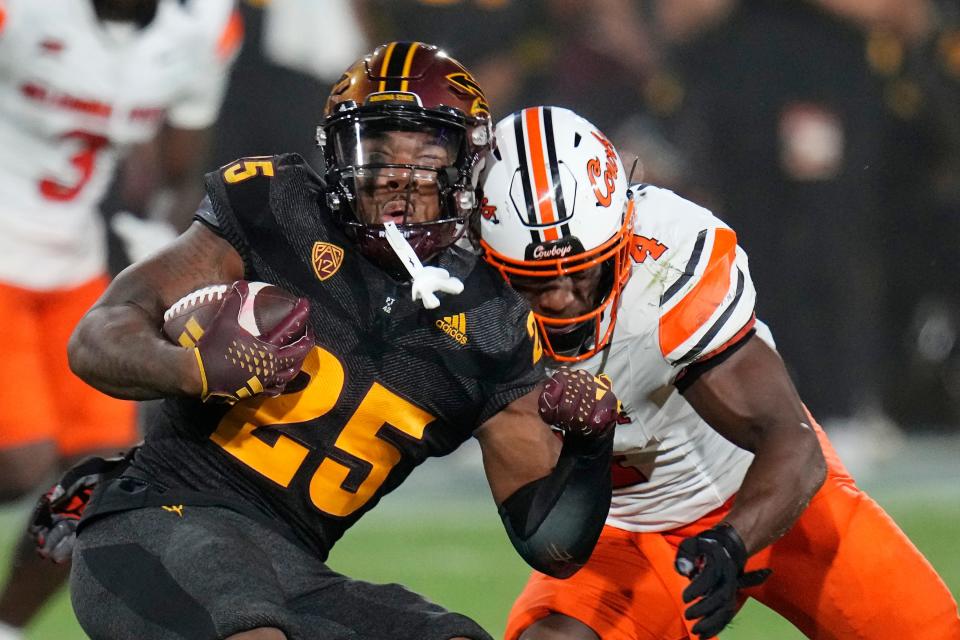 Arizona State running back DeCarlos Brooks (25) is tackled by Oklahoma State linebacker Nickolas Martin (4) during the second half of an NCAA college football game Saturday, Sept. 9, 2023, in Tempe, Ariz. Oklahoma State won 27-15. (AP Photo/Ross D. Franklin)