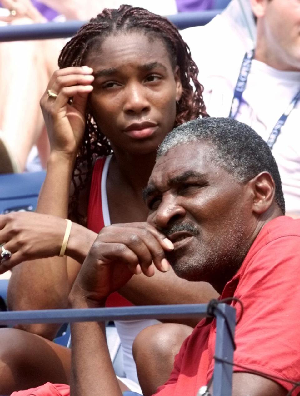 FILE - In this Sept. 4, 2000, file photo, Venus Williams watches her sister Serena play Australia's Jelena Dokic alongside her father and coach Richard Williams at the U.S. Open tennis tournament in New York. His new book, "Black and White: The Way I See It," comes out May 6. It goes into detail about how Indian Wells, as he writes, "disgraced America." (AP Photo/Suzanne Plunkett, File)