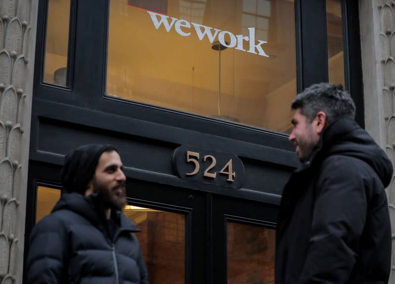 FILE PHOTO: People stand outside a WeWork co-working space in New York