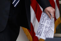 In this May 22, 2019, photo, President Donald Trump carries notes that say "they want to impeach me" as he walks from the Oval Office to speak in the Rose Garden of the White House in Washington. (AP Photo/Evan Vucci)