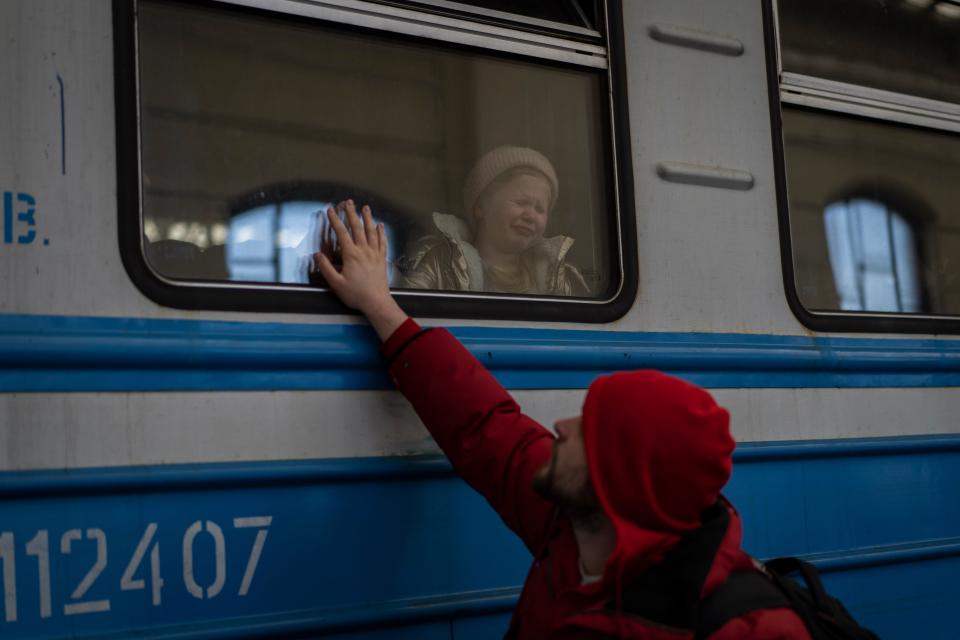 Displaced Ukrainians on a Poland-bound train bid farewell in Lviv, western Ukraine, on March 22, 2022.