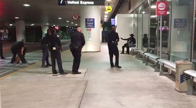 Six officers and a police dog surrounded the man dressed as 'Zorro' outside the terminal. Photo: Sam Macon