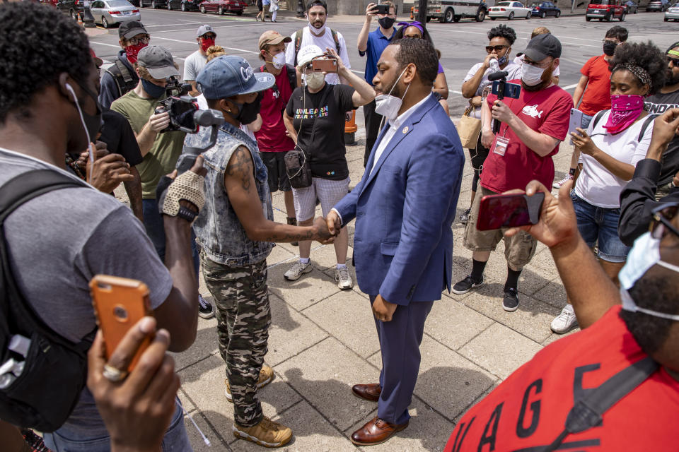 HOLD FOR STORY- In this June 17, 2020 photo U.S. Senate candidate Charles Booker shakes hands with protestors in Louisville, KY. Booker is running against Amy Grath for the senate democratic nomination. (Alton Strupp/Louisville Courier Journal via AP)