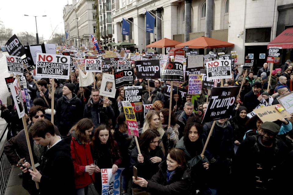 People hold placards as they take part in a protest march in London, against U.S. President Donald Trump's ban on travellers and immigrants from seven predominantly Muslim countries entering the U.S., Saturday, Feb. 4, 2017. (AP Photo/Matt Dunham)