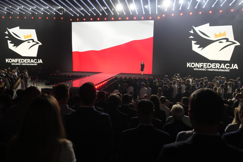 A woman sings the Polish national anthem at the start of a convention of the hard right Confederation party in Katowice, Poland, on Saturday, Sept. 23, 2023. Confederation has been growing in popularity, especially among young men. The party has been riding a wave of growing support for far-right parties across Europe, and polls show it could increase its presence in parliament in a national election Oct. 15. No matter how they do on election day, the party has already done a lot to push the government to take a more confrontational stance to Ukraine, which is fighting for its survival against Russia. (AP Photo/Czarek Sokolowski)