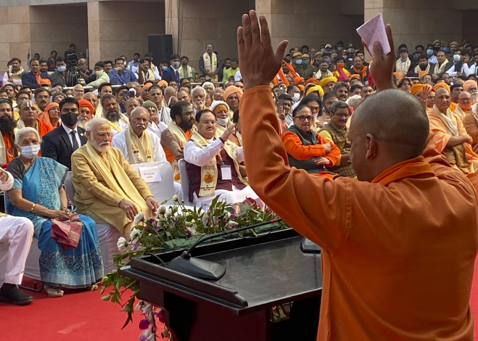 Indian Prime Minister Narendra Modi, second left, listens as Uttar Pradesh Chief Minister Yogi Adityanath addresses a gathering during the inauguration of Kashi Vishwanath Dham Corridor, a promenade that connects the sacred Ganges River with the centuries-old temple dedicated to Lord Shiva in Varanasi, India, Monday, Dec. 13, 2021. (AP Photo/Rajesh Kumar Singh)