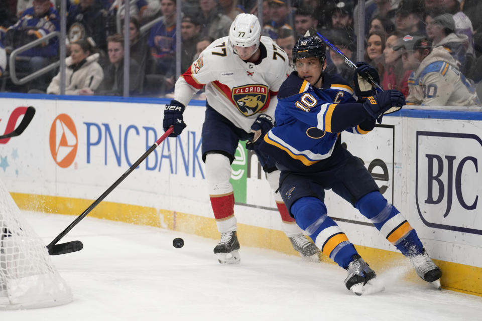 St. Louis Blues' Brayden Schenn (10) and Florida Panthers' Niko Mikkola (77) battle for a loose puck during the second period of an NHL hockey game Tuesday, Jan. 9, 2024, in St. Louis. (AP Photo/Jeff Roberson)