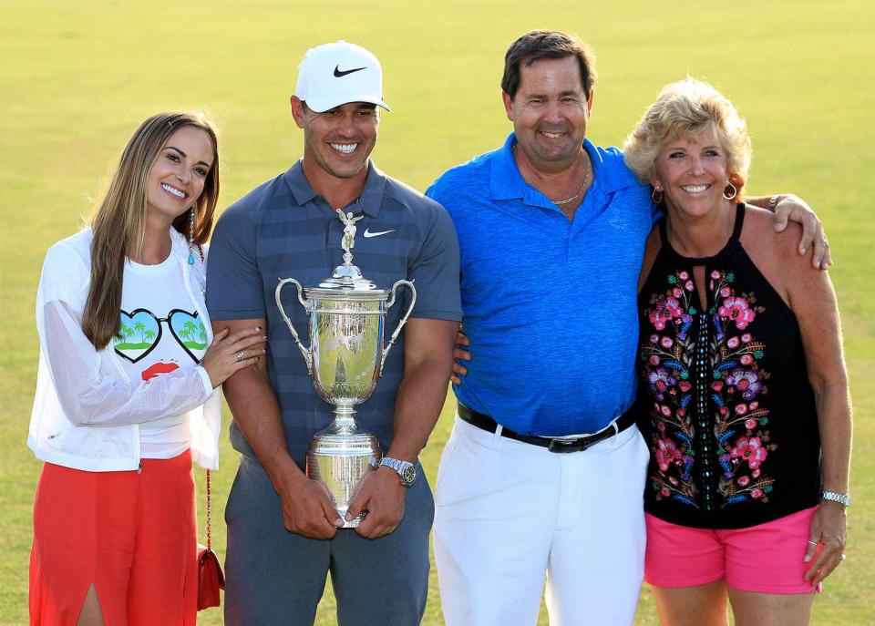 Brooks Koepka of the United States holds the trophy with his father Bob Koepka on Father's Day with his girlfriend Jena Sims and his mother Denise Jakows after his one shot victory during the final round of the 2018 US Open at Shinnecock Hills Golf Club on June 17, 2018 in Southampton, New York