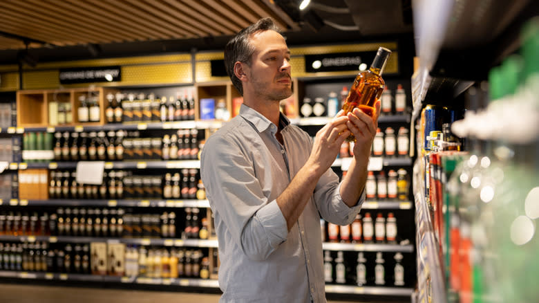 Un uomo con in mano una bottiglia di vino