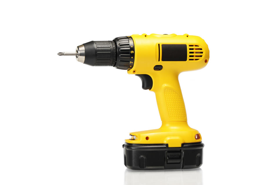 Cordless yellow and black drill on a white background