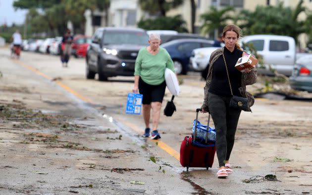 Residents leave with their belongings after an apparent tornado spawned from Hurricane Ian in Delray Beach on Wednesday. (Photo: Carline Jean/South Florida Sun-Sentinel via AP)