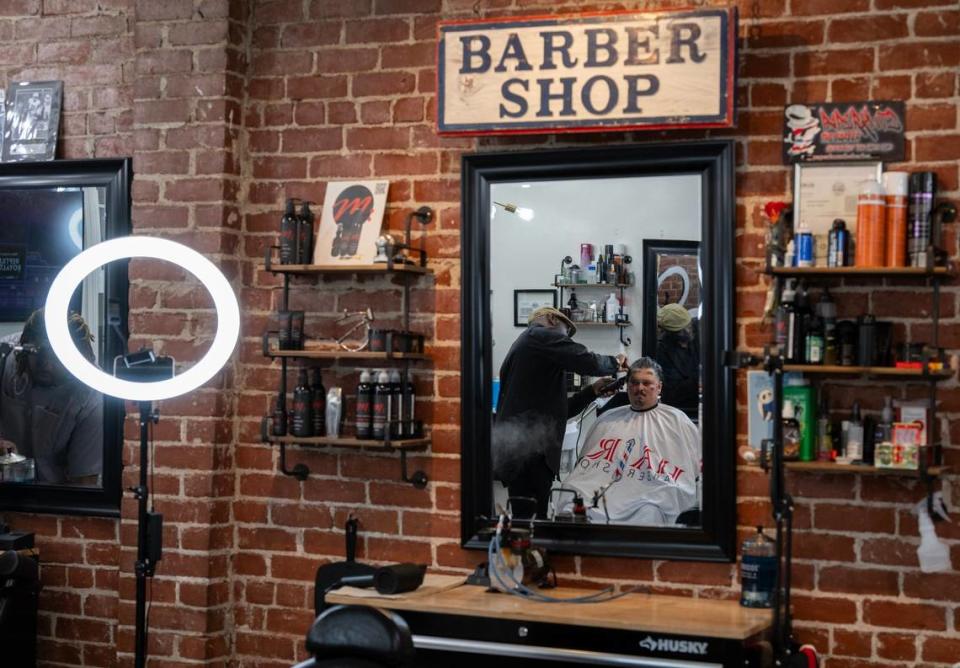 Marichal Brown cuts the hair of customer Joe Chavarria at HAIRitage Salon last month. Paul Kitagaki Jr./pkitagaki@sacbee.com
