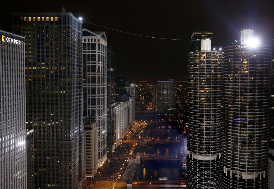 Daredevil Nik Wallenda walks along a tightrope between two skyscrapers suspended 500 feet (152.4 meters) above the Chicago River in Chicago, Illinois, November 2, 2014. (REUTERS/Jim Young)