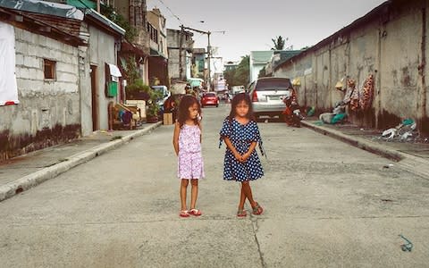 Ashlie (on the right) stands next to a normal size four-year-old, who is nine years younger than her - Credit: Simon Townsley