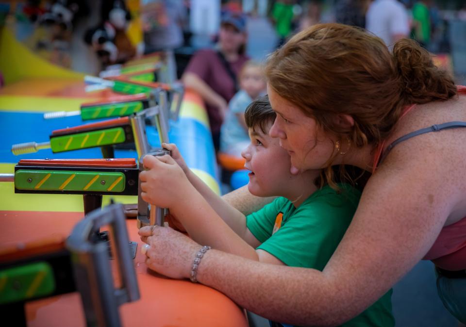 Braylen Stewart  and Aniston Stewart compete in a carnival game during the first day of the combined Wilson County Fair and Tennessee State Fair in Lebanon Thursday, August 12, 2021.