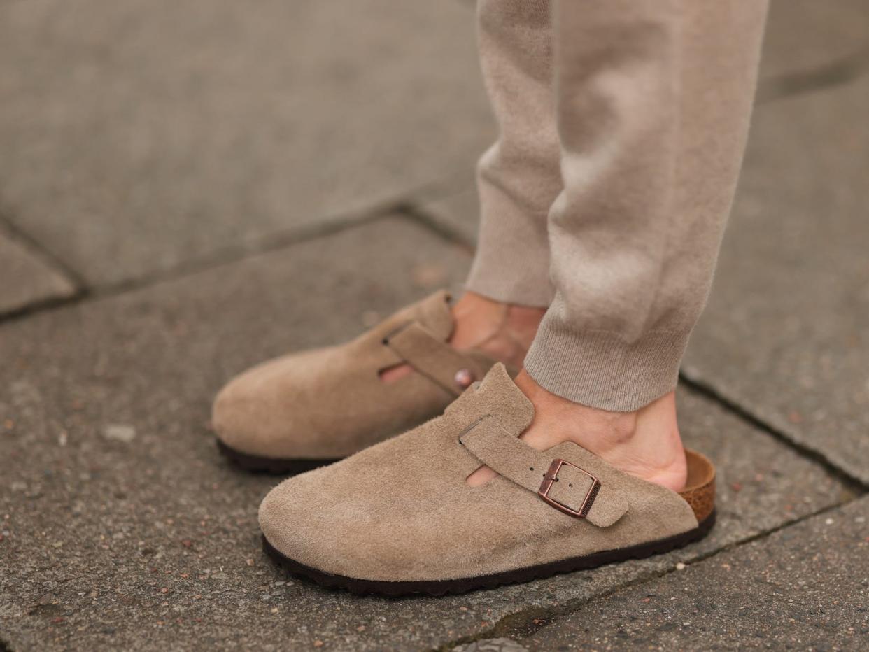 Birkenstock Boston clogs on the feet of a woman wearing tan sweatpants