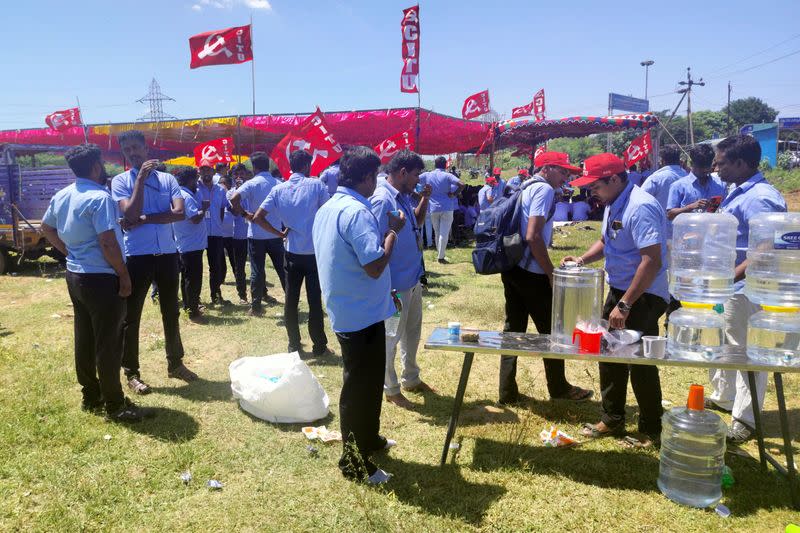 Workers of a Samsung facility drink tea as they gather to take part in a strike to demand higher wages at its Sriperumbudur plant