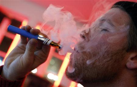 A customer puffs on an e-cigarette at the Henley Vaporium in New York City December 18, 2013. REUTERS/Mike Segar