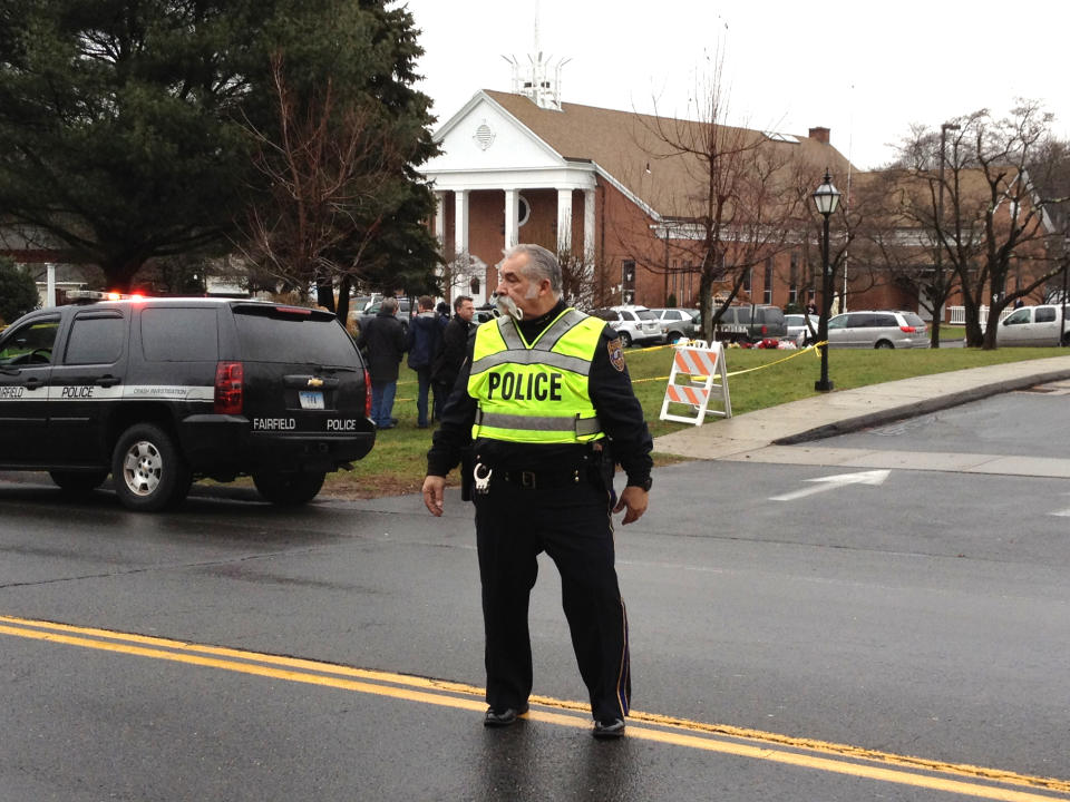 A police officer standing in the street directs traffic outside a funeral for Sandy Hook shooting victims.