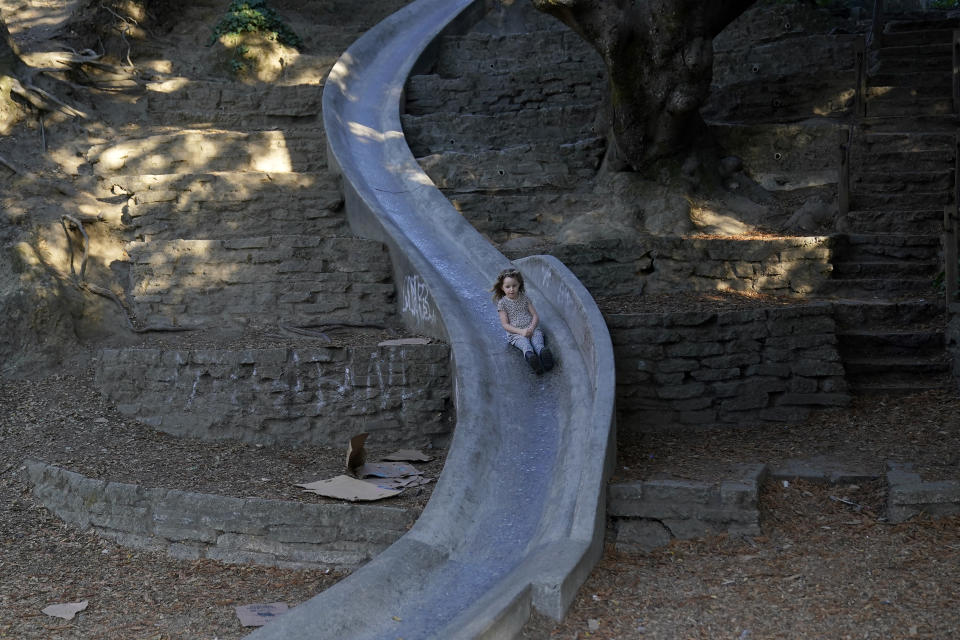 Aylah Levy, 6, rides down a concrete slide while interviewed with her mother, Hannah, in Berkeley, Calif., Wednesday, Nov. 8, 2023. (AP Photo/Jeff Chiu)