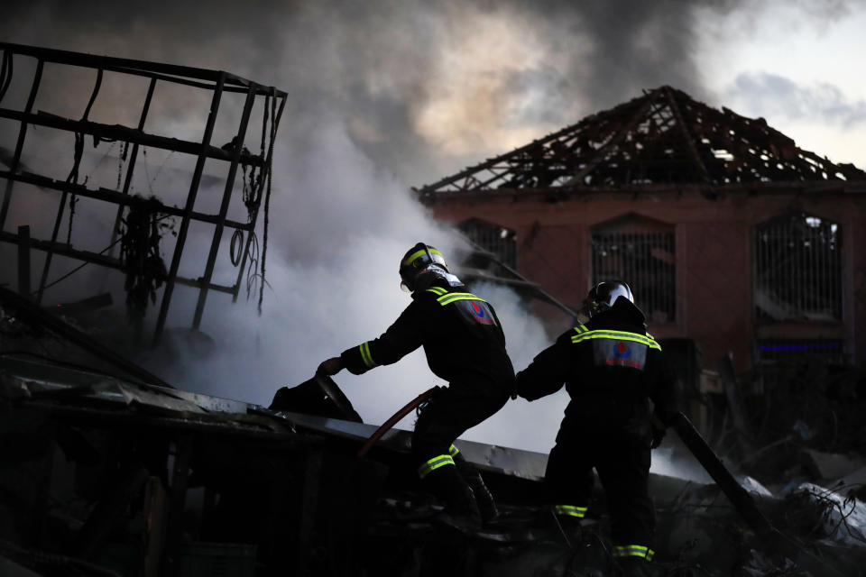 Firefighters extinguish fire at a destroyed warehouse, attacked by Israeli, strikes at an industrial district, in the southern coastal town of Ghazieh, Lebanon, Monday, Feb. 19, 2024. Israel's air force carried out at least two airstrikes near the southern port city of Sidon in one of the largest attacks near a major city, state media reported. (AP Photo/Mohammed Zaatari)