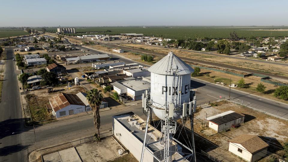 A water tower rises above Main Street in Pixley, Calif., on Tuesday, May 21, 2024. Some residents say dairies located throughout the region produce air pollution that is hurting their community. (AP Photo/Noah Berger)