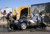 Syrian policemen inspect the site of a car bomb explosion on Mazzeh highway in the capital Damascus