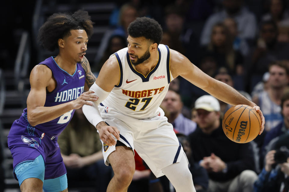 Denver Nuggets guard Jamal Murray (27) is defended by Charlotte Hornets guard Nick Smith Jr. during the first half of an NBA basketball game in Charlotte, N.C., Saturday, Dec. 23, 2023. (AP Photo/Nell Redmond)