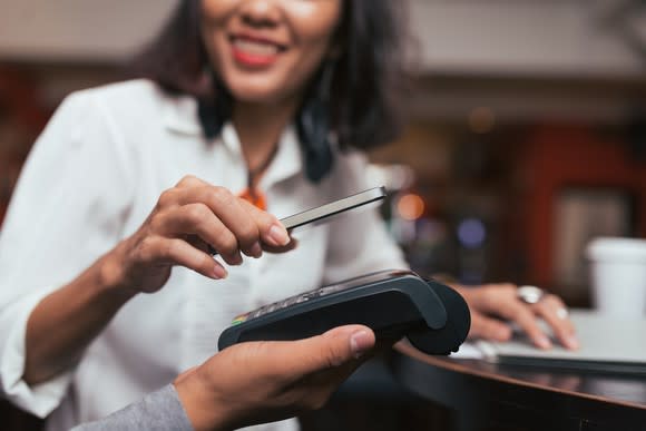 Woman using mobile phone to pay in a retail store.