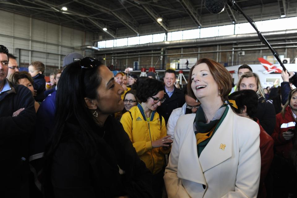 Prime Minister Julia Gillard speaks to families while she waits for London 2012 Olympic athletes to arrive at Sydney Airport Wednesday August 15, 2012 . (AAP Image/Mick Tsikas) NO ARCHIVING