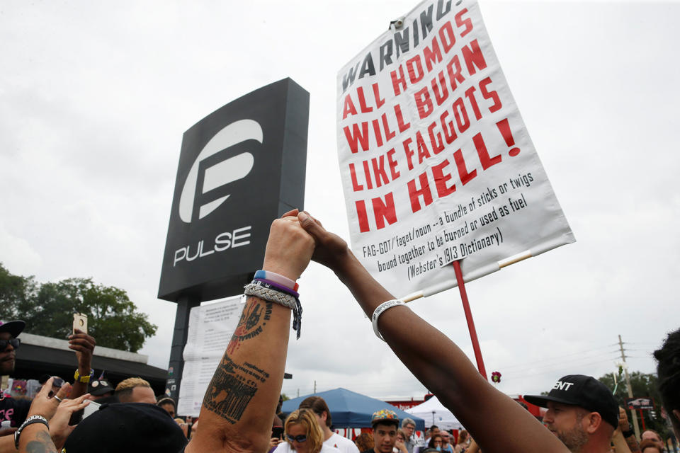 <p>Guests visiting the memorial outside the Pulse Nightclub on the one-year anniversary of the shooting raise their hands around a protester in Orlando, Florida, June 12, 2017. (Scott Audette/Reuters) </p>