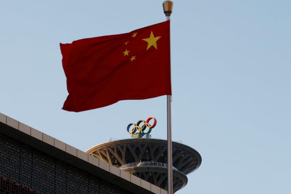 The Chinese flag flutters near the Olympic rings (REUTERS)