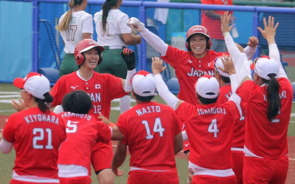 Japan's Mana Atsumi (centre L) and Eri Yamada (centre R) celebrate their victory with their teammates (front) during the Tokyo 2020 Olympic Games softball opening round game between Mexico and Japan at Fukushima Azuma Baseball Stadium in Fukushima, Japan, on July 22, 2021. - AFP