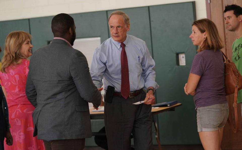 In this file photo from 2018, U.S. Sen. Tom Carper shake hands with voters in the registration line at P.S. DuPont High School before casting his own votes.