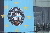 A basketball team walks through a crosswalk to the Indiana Convention Center for the NCAA college basketball tournament, Wednesday, March 17, 2021, in Indianapolis. (AP Photo/Darron Cummings)