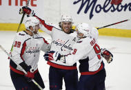 Washington Capitals right wing T.J. Oshie (77) celebrates his hat trick goal against the Ottawa Senators with right wing Anthony Mantha (39) and defenseman Dmitry Orlov (9) during second-period NHL hockey game action in Ottawa, Ontario, Monday, Oct. 25, 2021. (Justin Tang/The Canadian Press via AP)