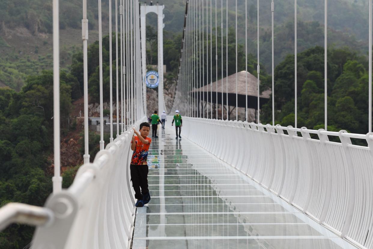 a child clings to the railing on the Bach Long glass bridge in the Moc Chau district in Vietnam's Son La province