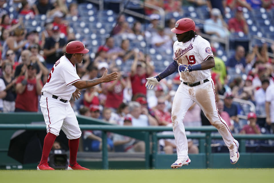 Washington Nationals' Josh Bell rounds the bases past interim third base coach Henry Blanco after hitting a three-run home run in the fifth inning of a baseball game against the Philadelphia Phillies, Thursday, Aug. 5, 2021, in Washington. (AP Photo/Patrick Semansky)