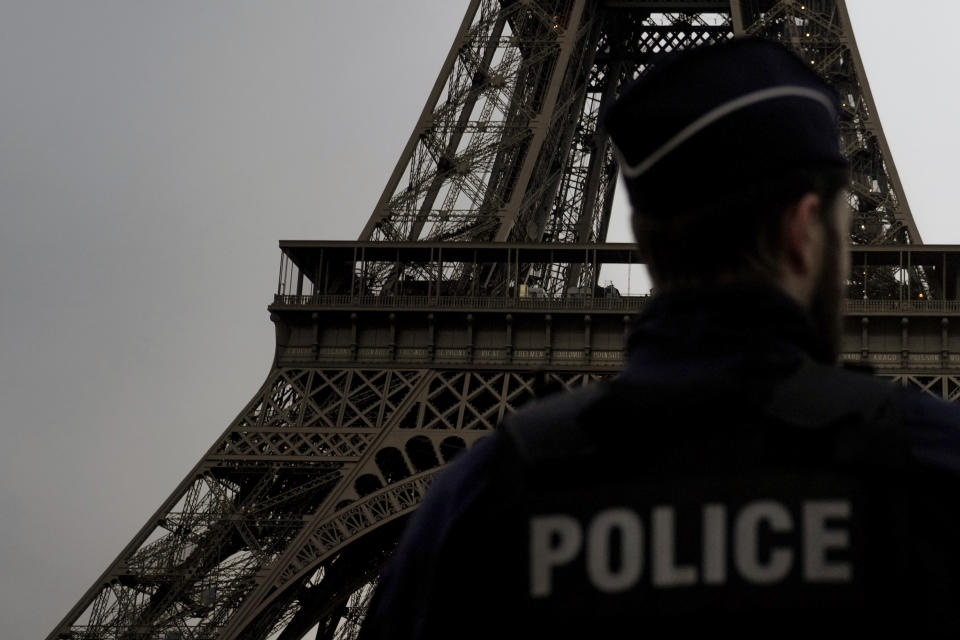 A French policeman patrols near the Eiffel Tower, in Paris, Thursday, Dec. 7, 2023. Less than a year before the 2024 Paris Olympic Games, with an opening ceremony on the nearby Seine river, the bar was already high. But the security challenge went up with the deadly weekend knife attack that killed a tourist near the Eiffel Tower, a tourist magnet that is the symbol of Paris. (AP Photo/Thibault Camus)
