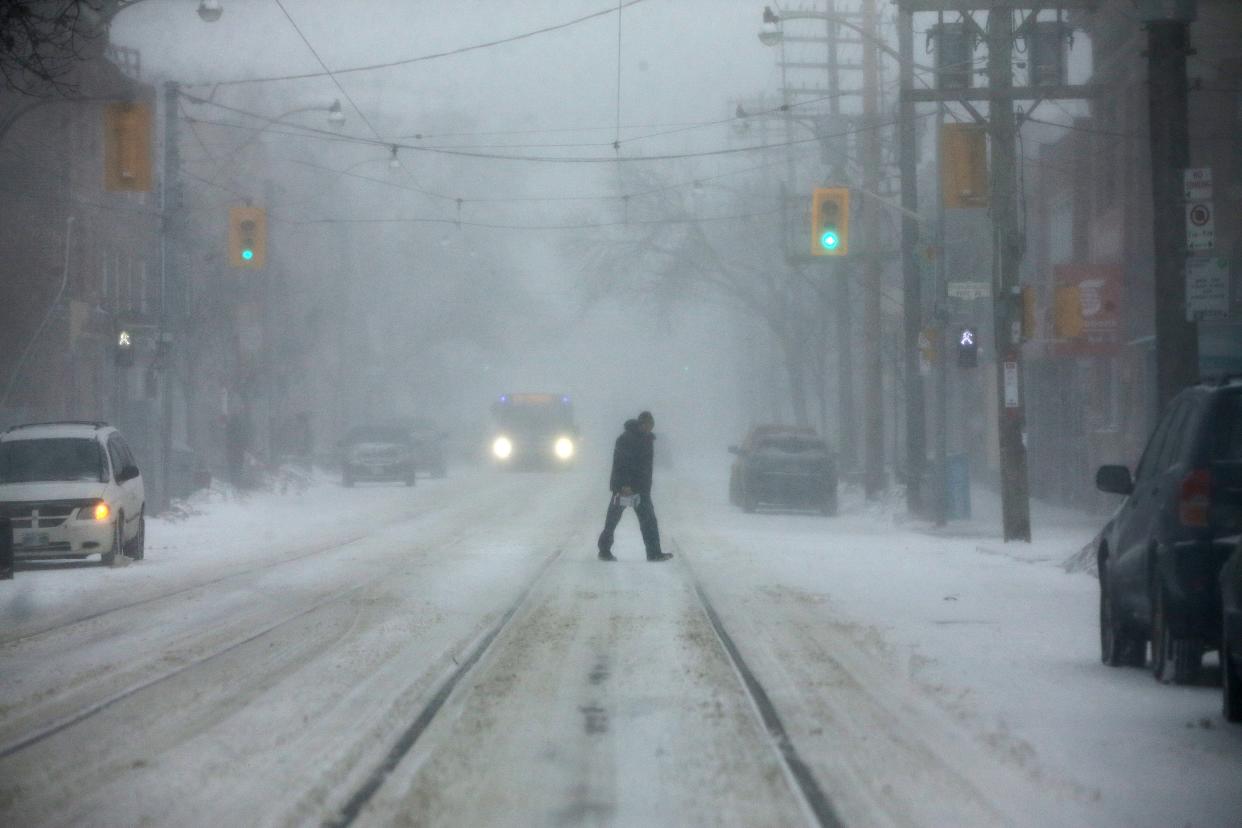 TORONTO, ON- FEBRUARY 12:  A pedestrian walks across an empty Queen Street. A winter storm with a combination of 15 to 25 cm snow and ice pellets, possible freezing rain, and strong winds  gusting near 70 km/h hits  in Toronto.        (Steve Russell/Toronto Star via Getty Images)