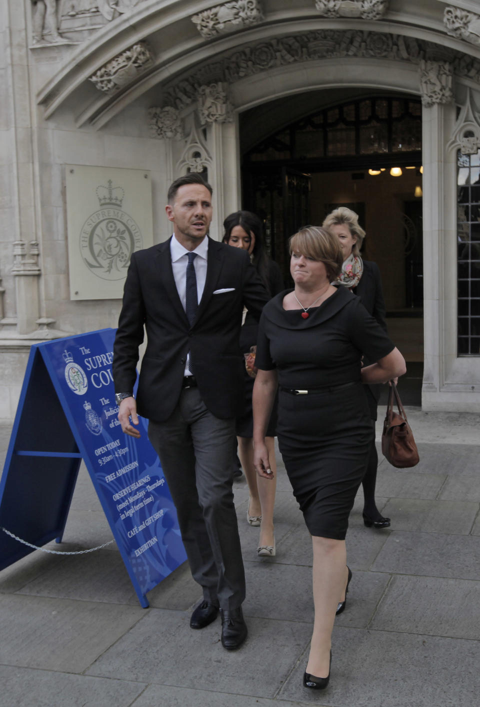 Private investigator Glenn Mulcaire, left, and his wife Alison, right, leave Britain's Supreme Court in central London, Tuesday, May 8, 2012. Mulcaire, jailed for hacking phones for Rupert Murdoch's News of the World, asked Britain's Supreme Court on Tuesday to back his bid to keep mum about who ordered him to conduct the illegal eavesdropping. (AP Photo/Lefteris Pitarakis)