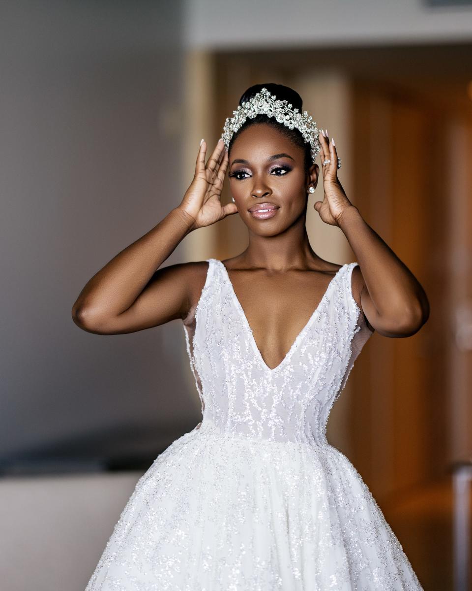 A bride adjusts her tiara on her wedding day.