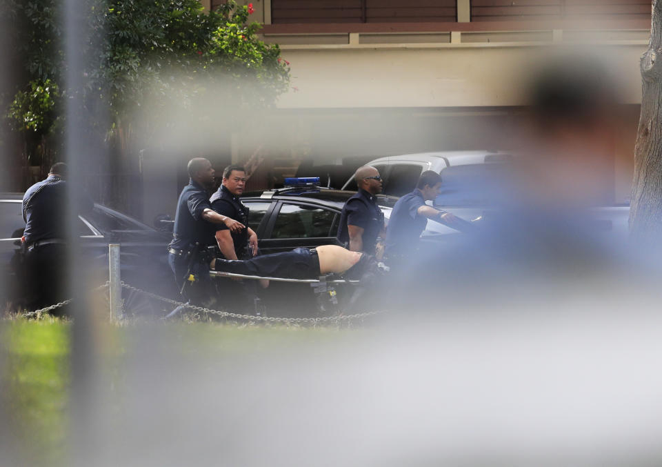 Honolulu police carry an injured officer after a shooting and domestic incident at a residence on Hibiscus Road near Diamond Head on Sunday, Jan. 19, 2020, in Honolulu. Witnesses say at least two Honolulu police officers were shot and two civilians were injured. (Jamm Aquino/Honolulu Star-Advertiser via AP)