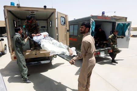 Afghan military medical personnel take an injured member of the Afghan security forces off an ambulance, prior to air transport for treatment in Kabul, at the Kandahar military Airport, Afghanistan July 9, 2017. REUTERS/Omar Sobhani