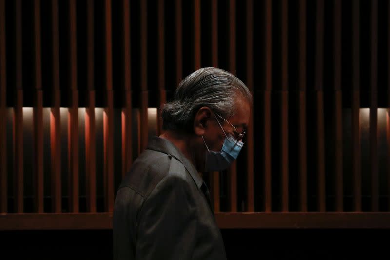 FILE PHOTO: Malaysia's former Prime Minister Mahathir Mohamad wearing protective mask arrives for a news conference in Putrajaya