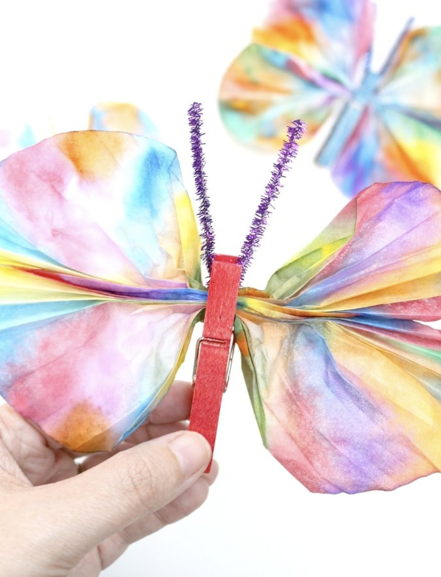 crafts for kids, hand holding a diy coffee filter butterfly